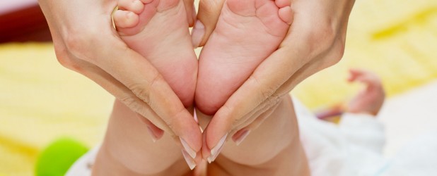 Мама делает массаж ног малышу