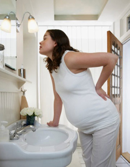 беременная девушка смотрится в зеркало