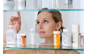 женщина выбирает осматривает лекарства на полке