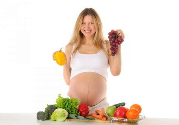 Беременная девушка с овощами и фруктами