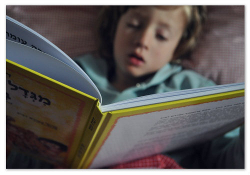 Ребенок читает книгу.