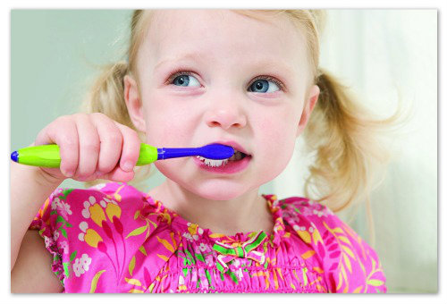 Девочка чистит зубы.