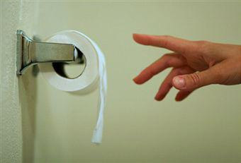 рука тянется к туалетной бумаге