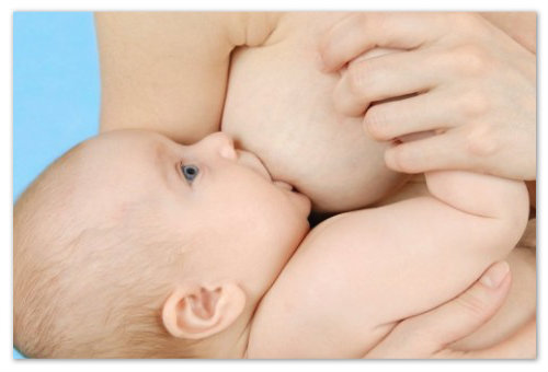 Младенец сосет грудь.