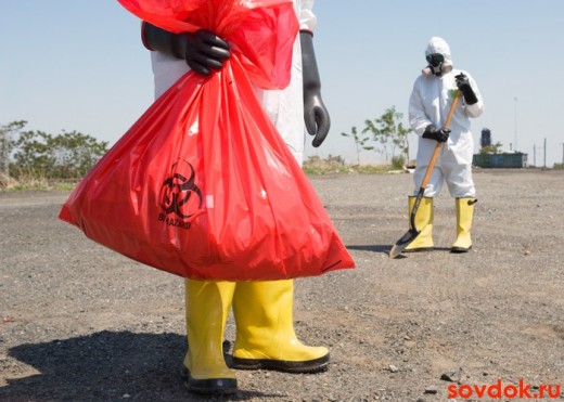 люди в костюмах собирают токсические отходы