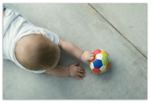 Ребенок играет с мячом.
