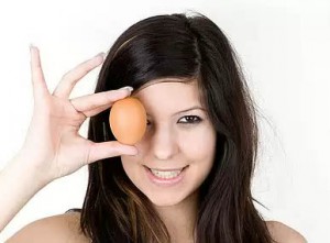 куриное яйцо в руке у девушки