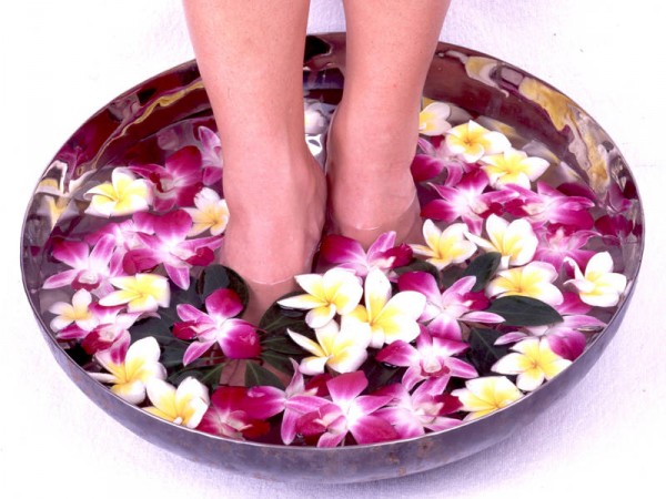 Ноги опущены в ванночку с красивыми цветами
