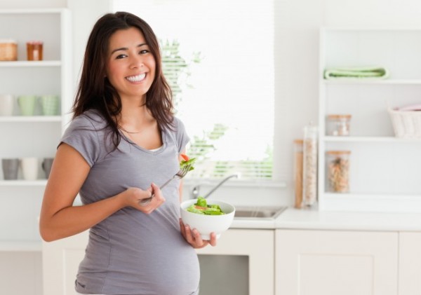 Беременная женщина ест салат