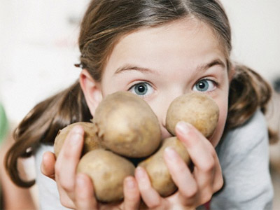 Девочка с картофелем в руках